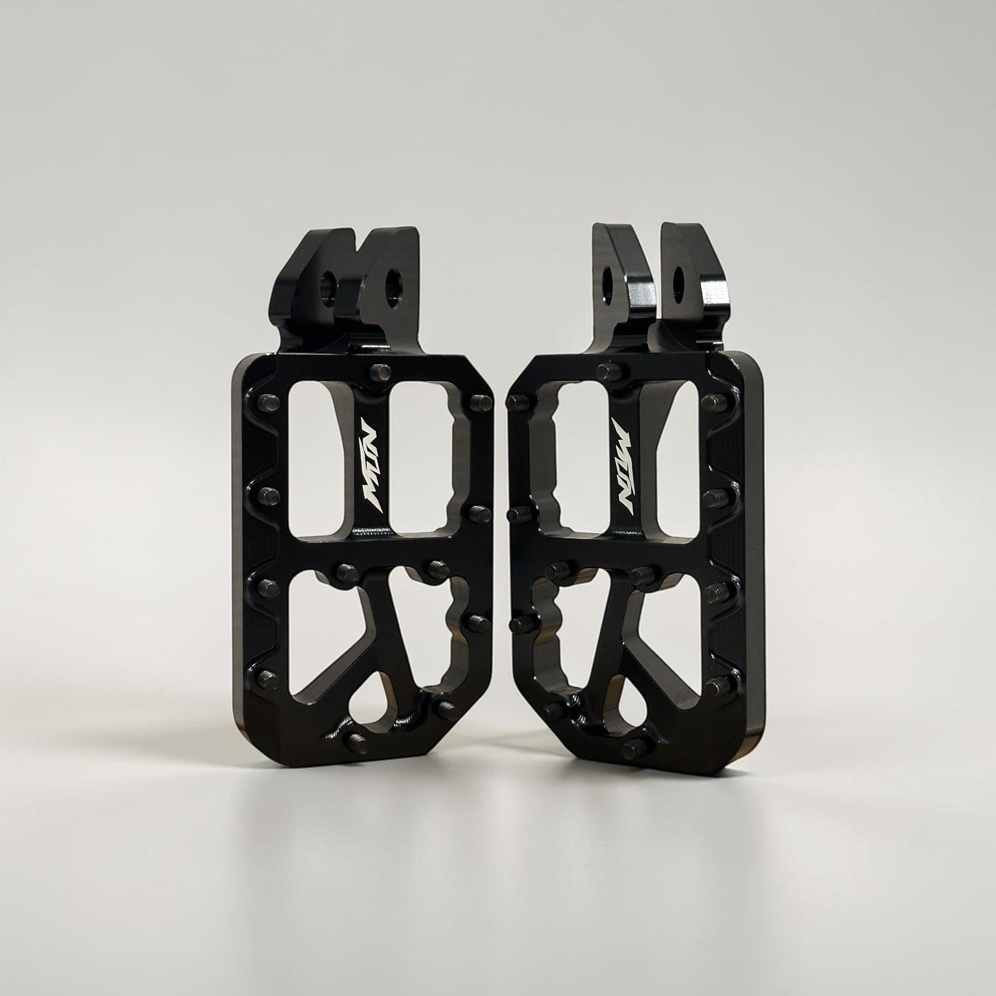 Black MTN Footpegs V1 Series with black titanium grip pins for aggressive e-moto riding