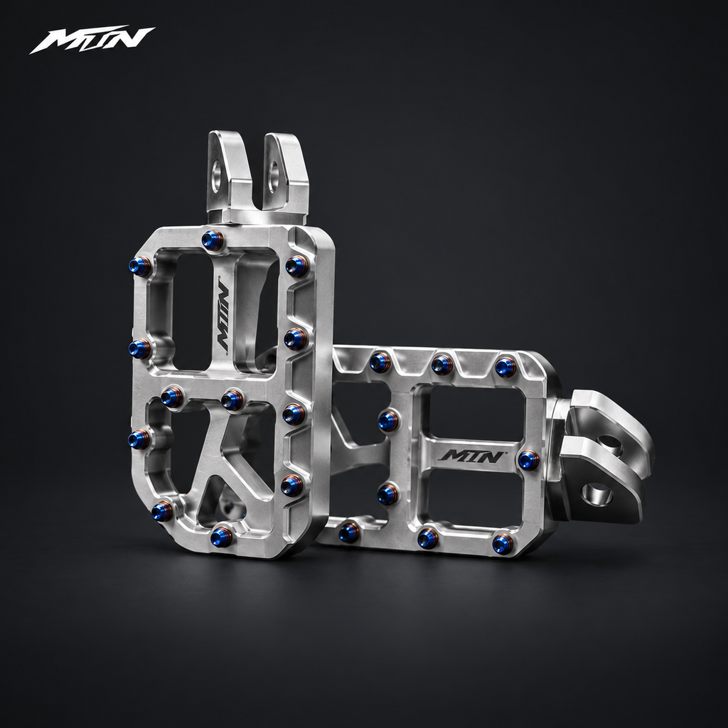 MARK I 7075 wide footpegs with 57mm platforms, raw silver finish and oil slick titanium pins, angled view