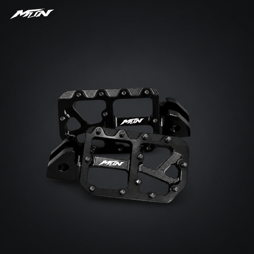 MARK I 7075 wide footpegs with 57mm platforms, stealth black finish and black titanium pins, angled view