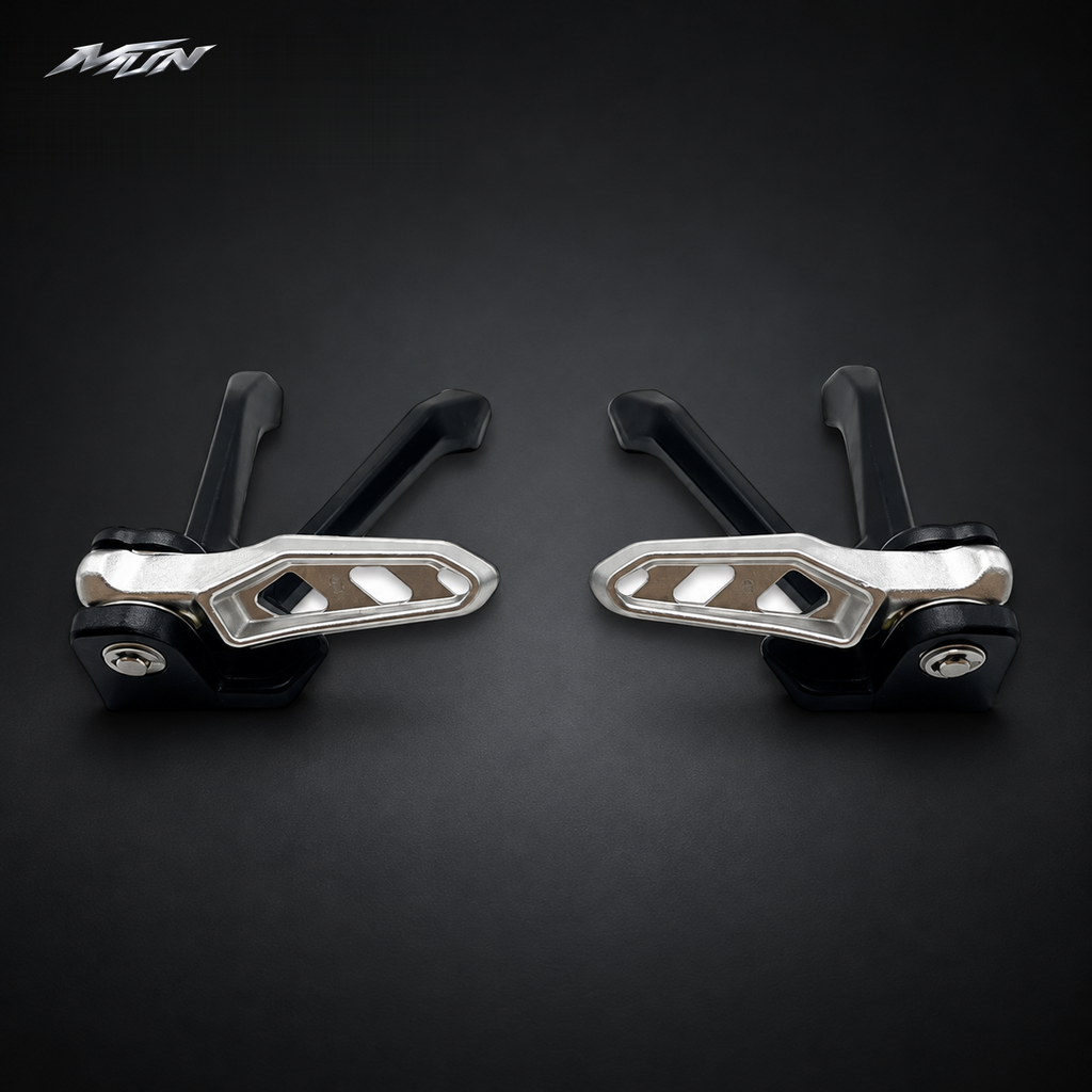 Top-down view of Sur-Ron Ultra Bee passenger footpeg pair folded in and locked against the black brackets — MTN MotoWorks
